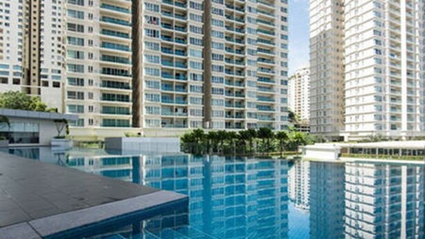 A modern high-rise building with a large swimming pool in the foreground. - Bangsar Camelia Homestay KL (Kuala Lumpur)