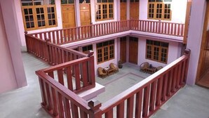 Un edificio a più piani con porte in legno e una ringhiera rossa.