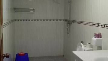 A bathroom with a shower, toilet, and sink.