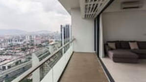 A balcony with a city view, a sofa, and a railing. - Pipit Homestay at Element Ampang (Kuala Lumpur)