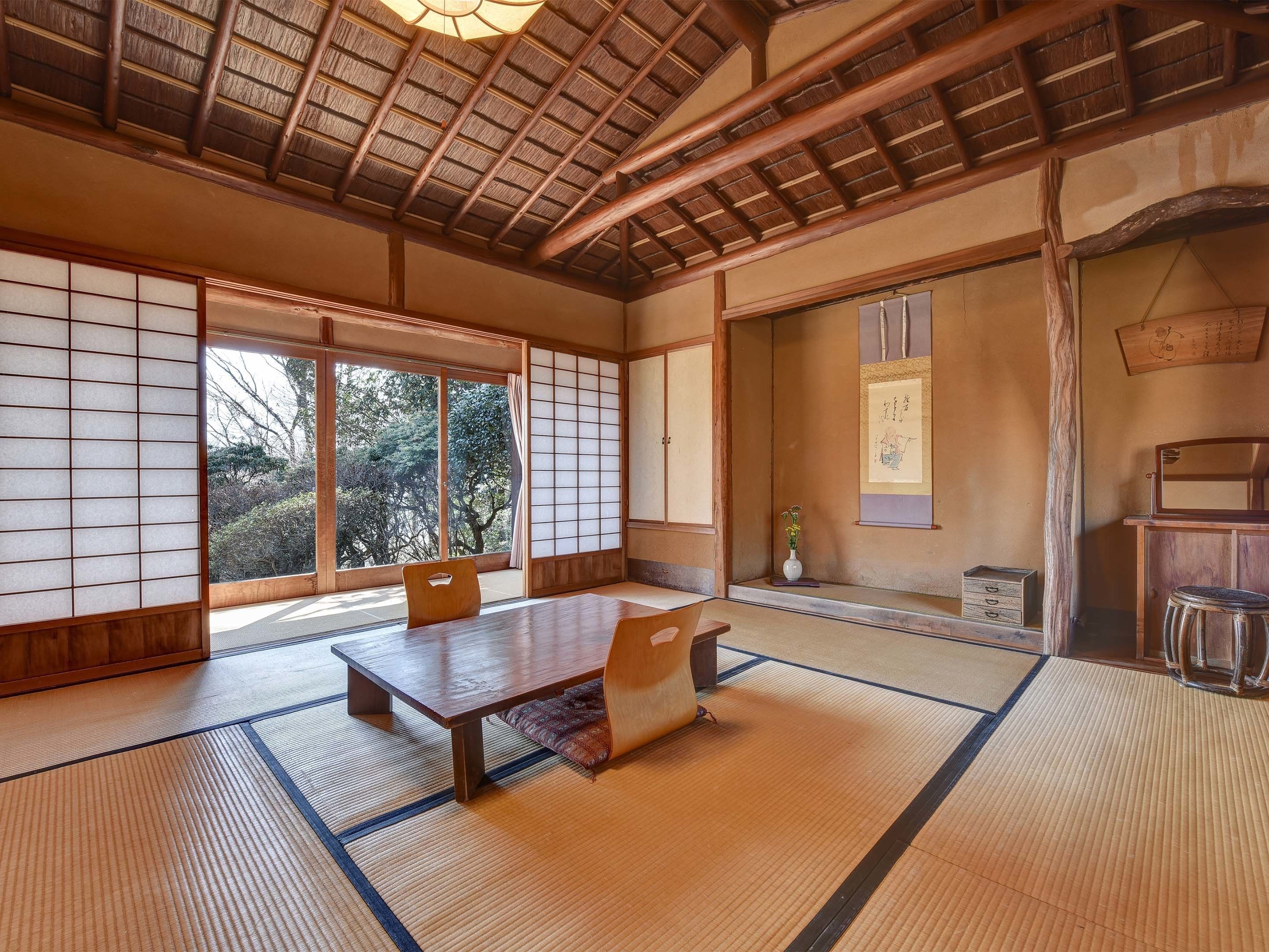 A traditional Japanese room with tatami flooring, a low table, and sliding doors.