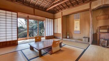 A traditional Japanese room with tatami flooring, a low table, and sliding doors.