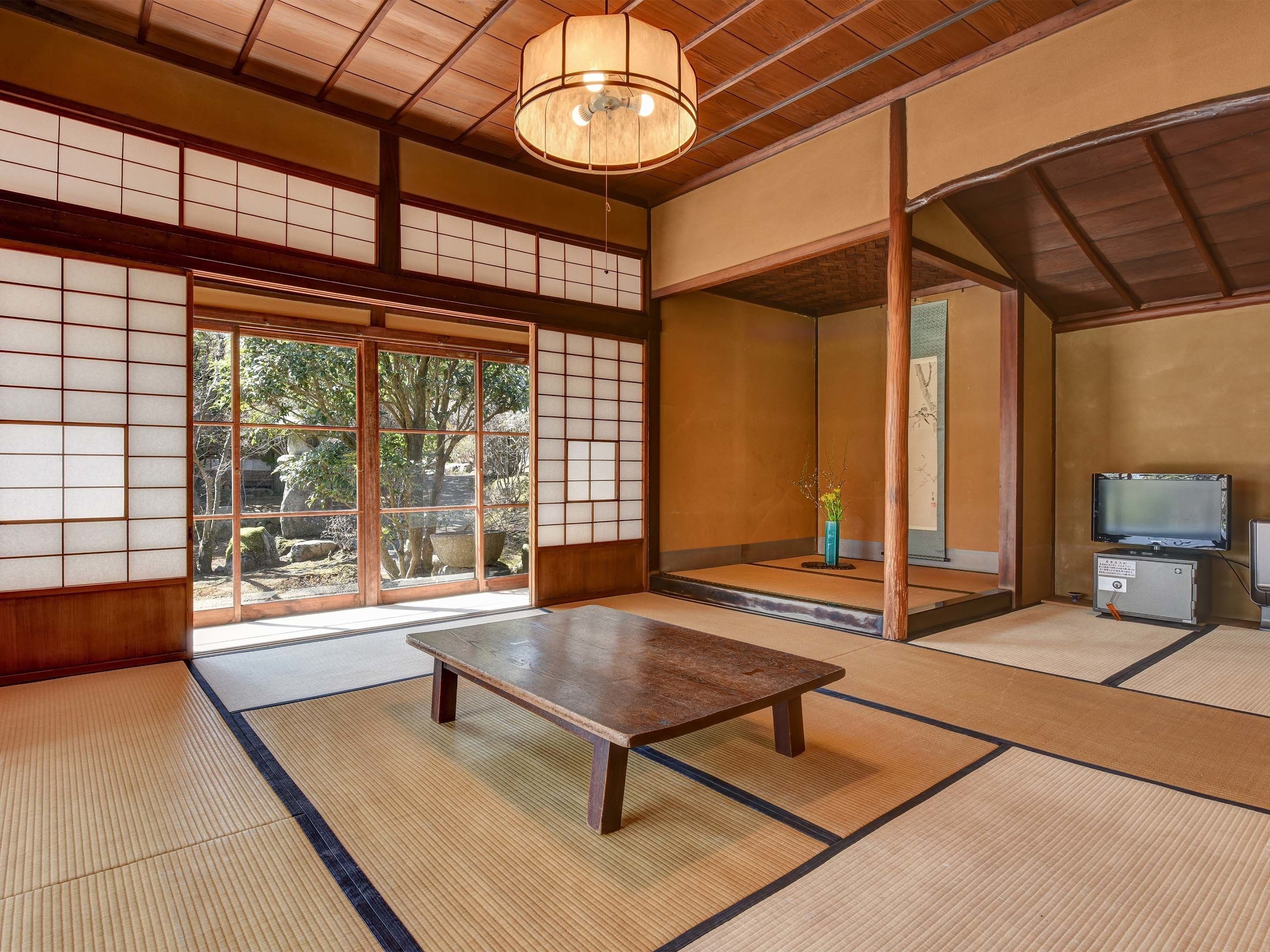 A traditional Japanese room with tatami flooring, sliding doors, and a wooden table.