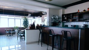 Una cucina moderna con angolo bar, ampie finestre e pavimento piastrellato pulito.