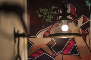 Una habitación con un mural de grafiti y un lámpara colgante.