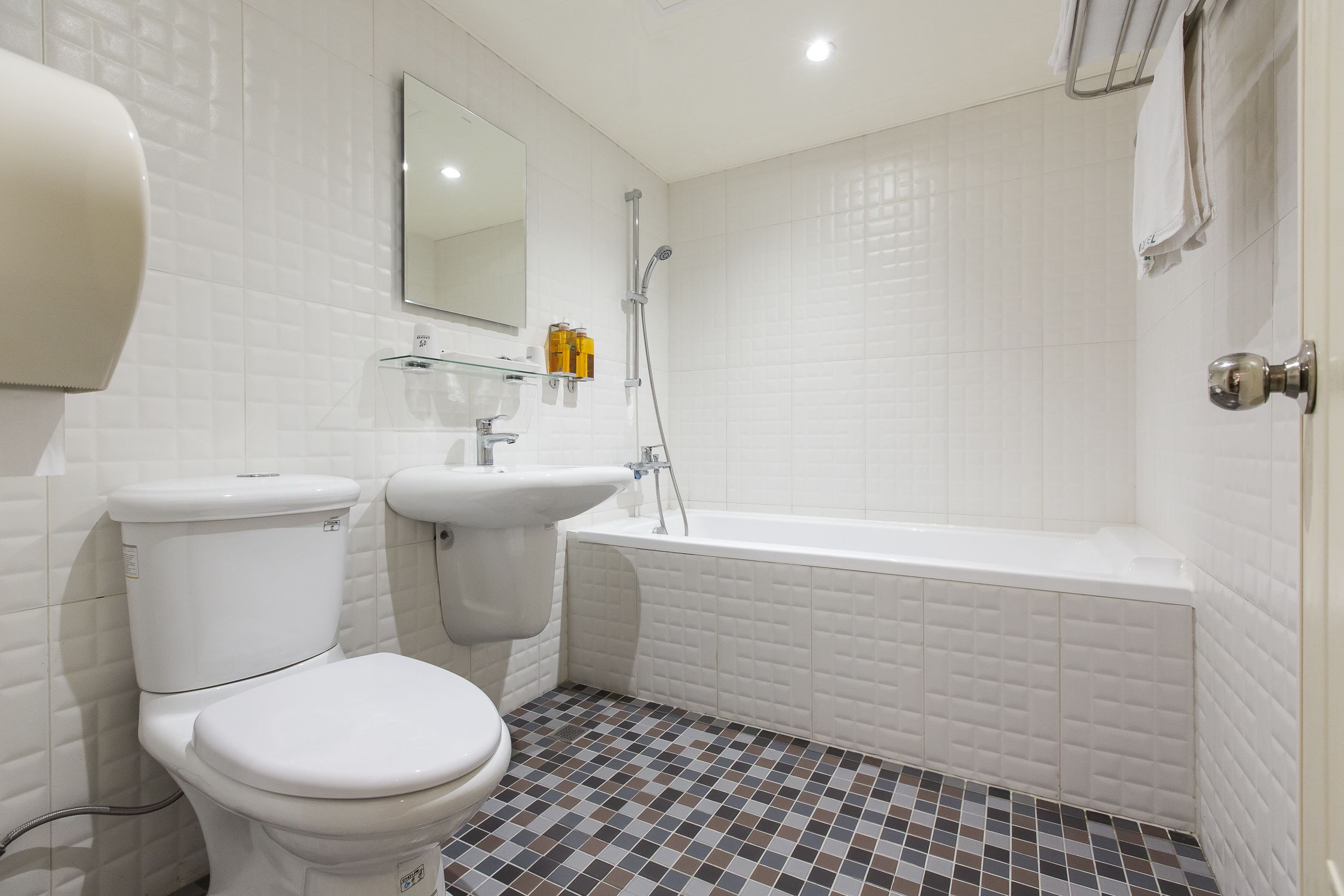 A bathroom with a toilet, sink, and bathtub.