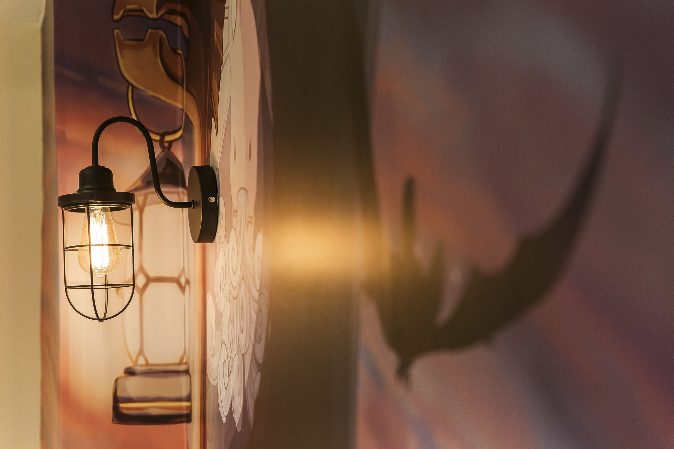 A wall-mounted light fixture with a visible switch and a wall with a geometric pattern.