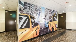 Un couloir orné d’une grande fresque représentant des taxis et un lama.