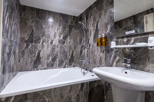 A modern bathroom with a bathtub, a sink, and a shower.