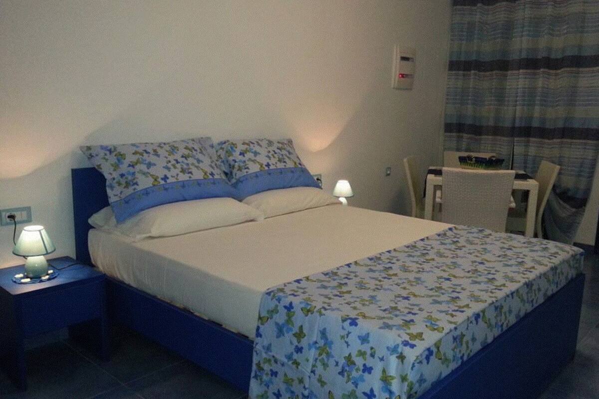 Hotellihuone, jossa on sänky, työpöytä ja tuoli.