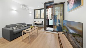 Un salon moderne avec un canapé, une table basse et un téléviseur.