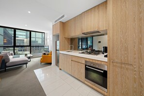 Una cocina moderna con armarios de madera, horno empotrado y un amplio ventanal con vistas a la ciudad.
