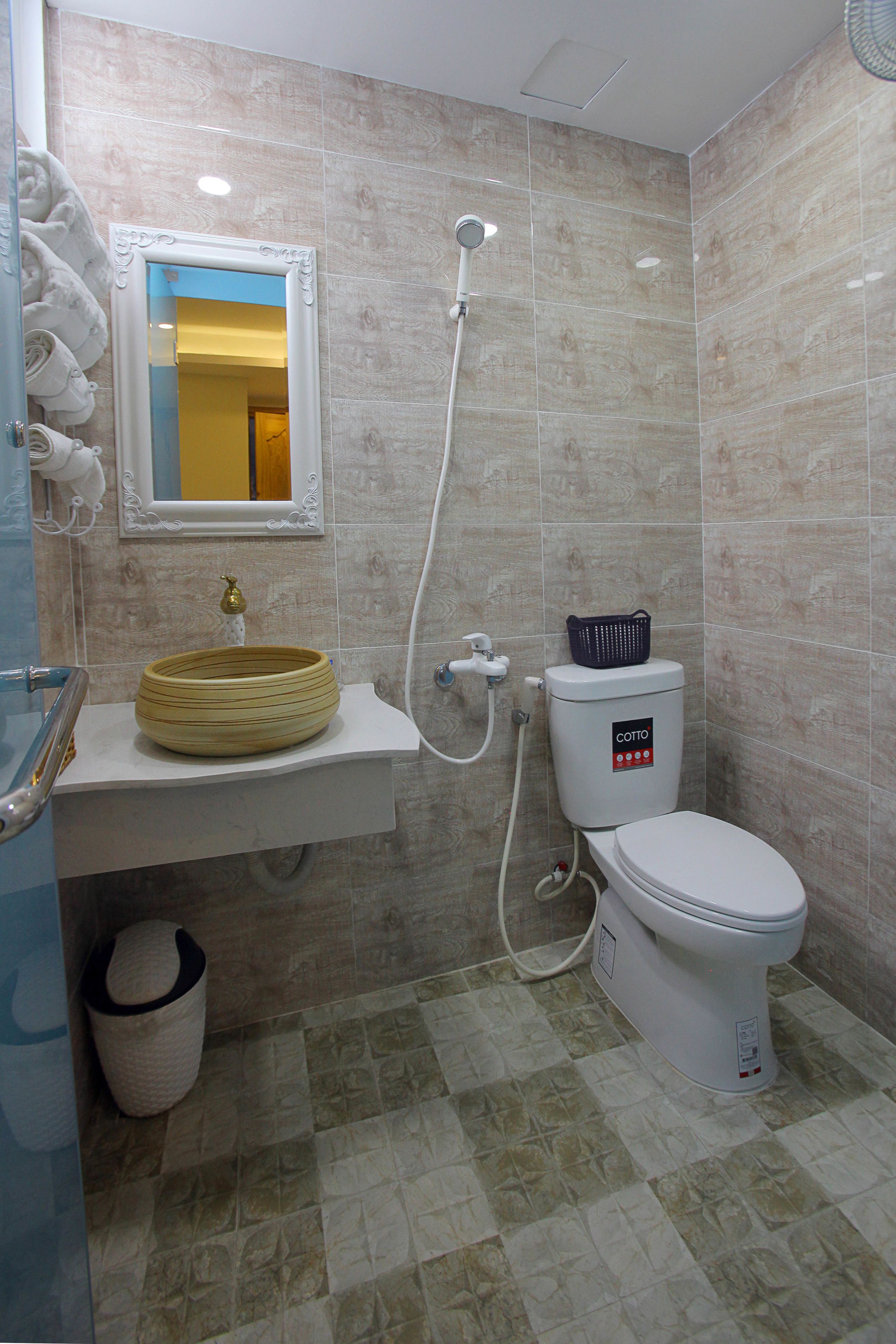 Een badkamer met wastafel, toilet en douche.