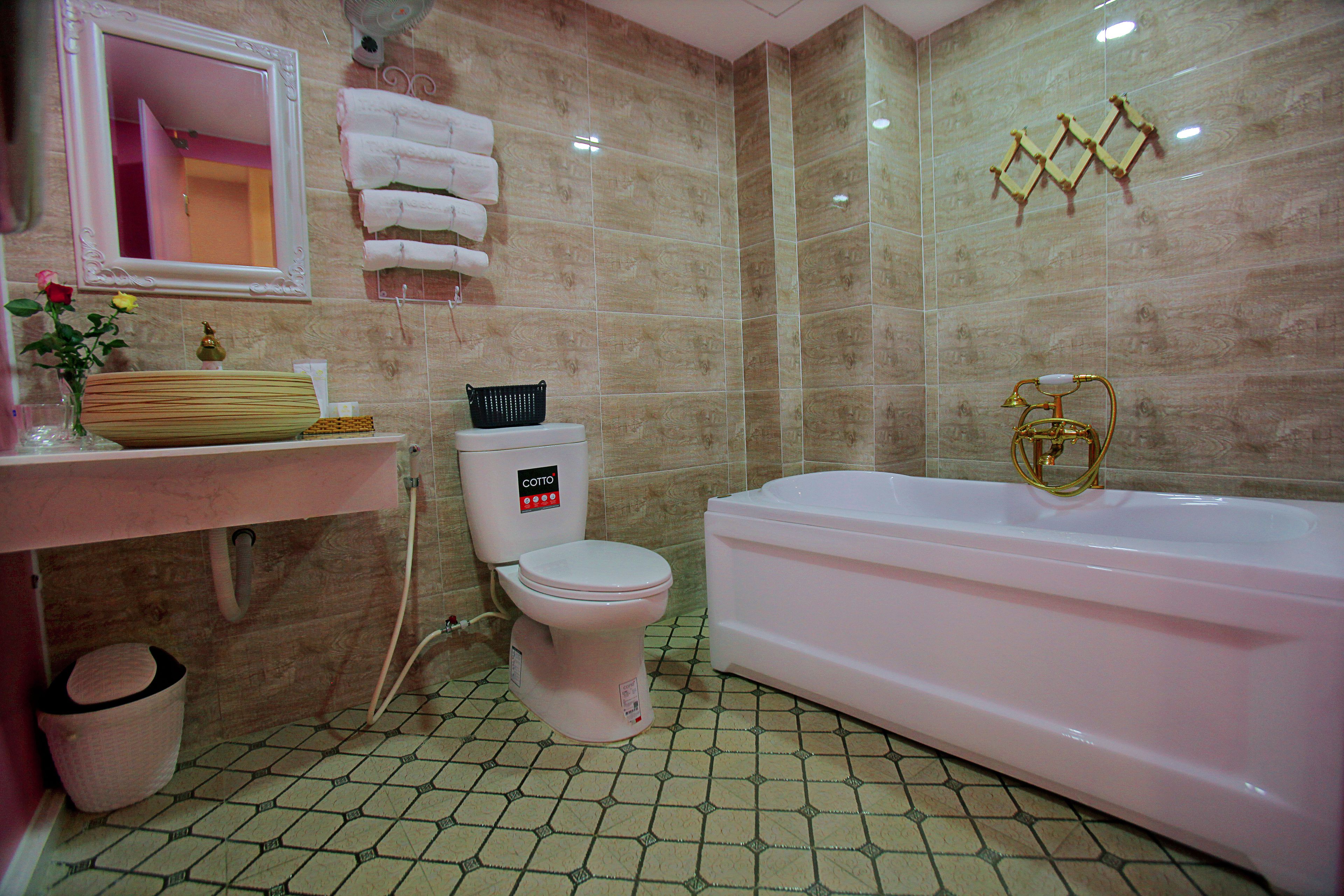 A bathroom with a toilet, bathtub, sink, and mirror.