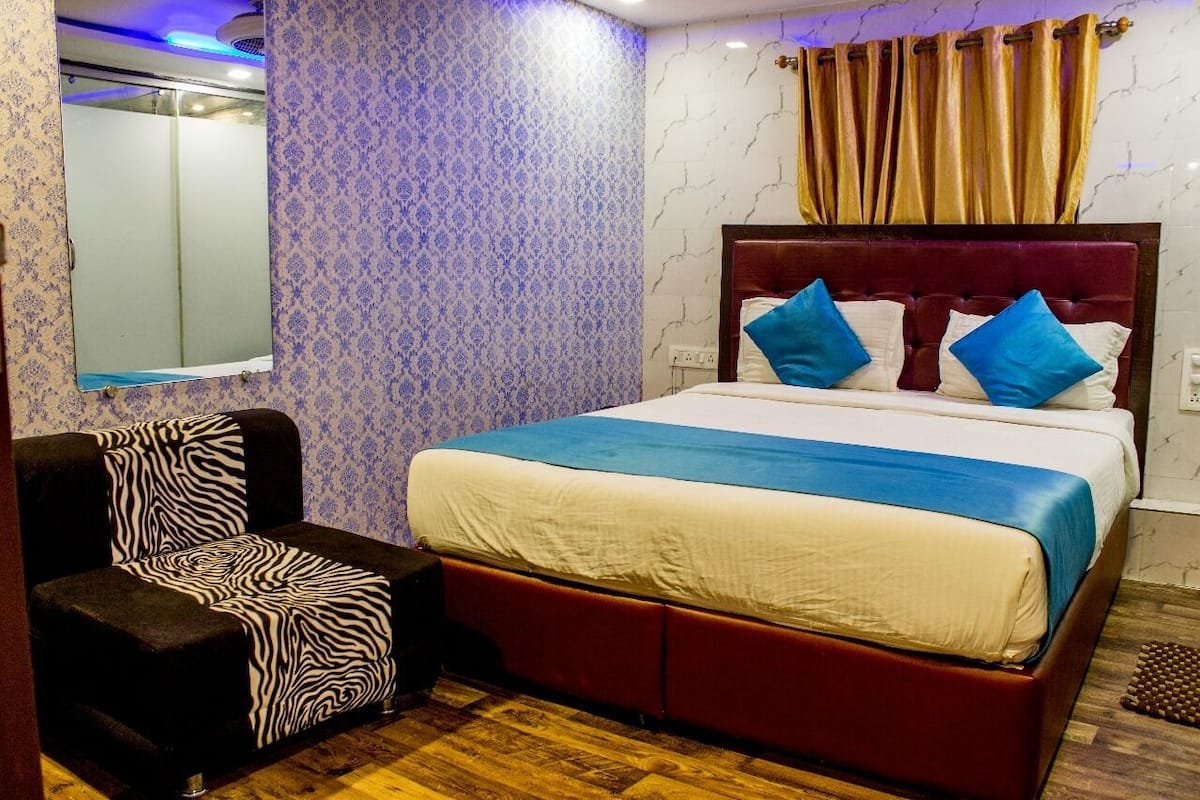 A bedroom with a bed, a zebra-patterned chair, and a mirror.