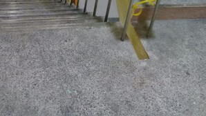 A staircase with wooden handrails and yellow safety ropes.