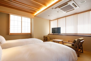 A hotel room with two beds, a television, a small table, and a chair. - Minato Koyado Awajishima (Minamiawaji)