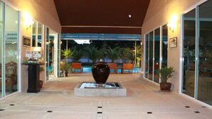A covered outdoor area with a central water feature, seating, and potted plants. - Suanson Paragon Green Villas (Rayong)