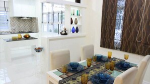 A dining area with a table set for six, featuring blue glassware and a decorative runner. - Suanson Paragon Green Villas (Rayong)