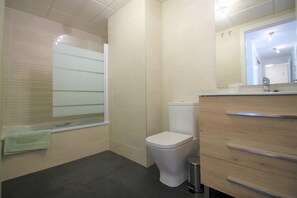 A bathroom with a toilet, a sink, and a mirror. - Apt. CasaTuris Residencial San Juan (Alicante)