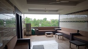 A modern interior with a balcony, seating area, and a trash bin. - Sagar Resort (Chhatrapati Sambhajinagar)