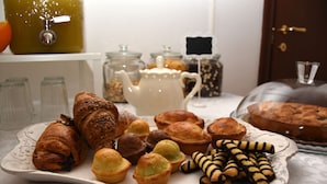 Une variété de viennoiseries et de pâtisseries disposées sur un plateau, notamment des croissants, des muffins et des biscuits.