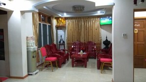A living room with red furniture, a television, and a wooden cabinet.