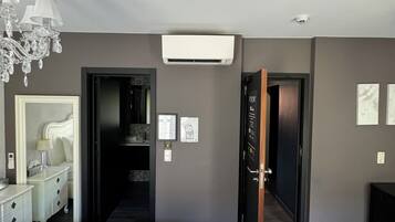 Hotelkamer met een bed, nachtkastje, kaptafel, kroonluchter en airconditioning.