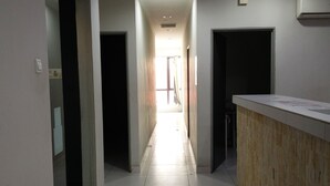 A hotel hallway with a reception desk, a clock, and a sign indicating the direction to the elevator. - My Homie Hotel PJ (Petaling Jaya)