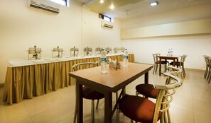 Ein Konferenzraum mit langem Tisch, Stühlen und einem Büfett.
