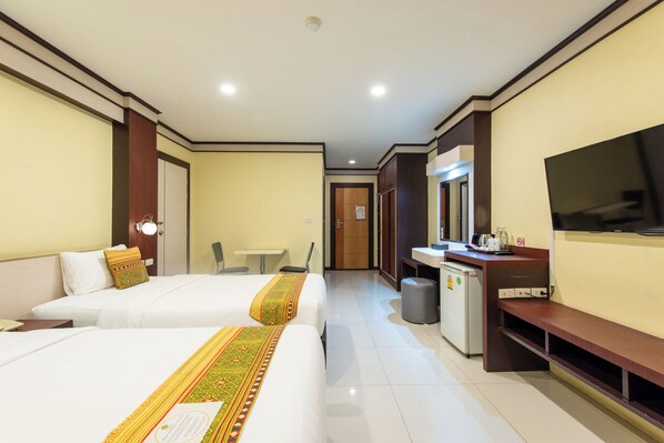 Une chambre d’hôtel avec deux lits, un bureau, une télévision et une petite kitchenette.