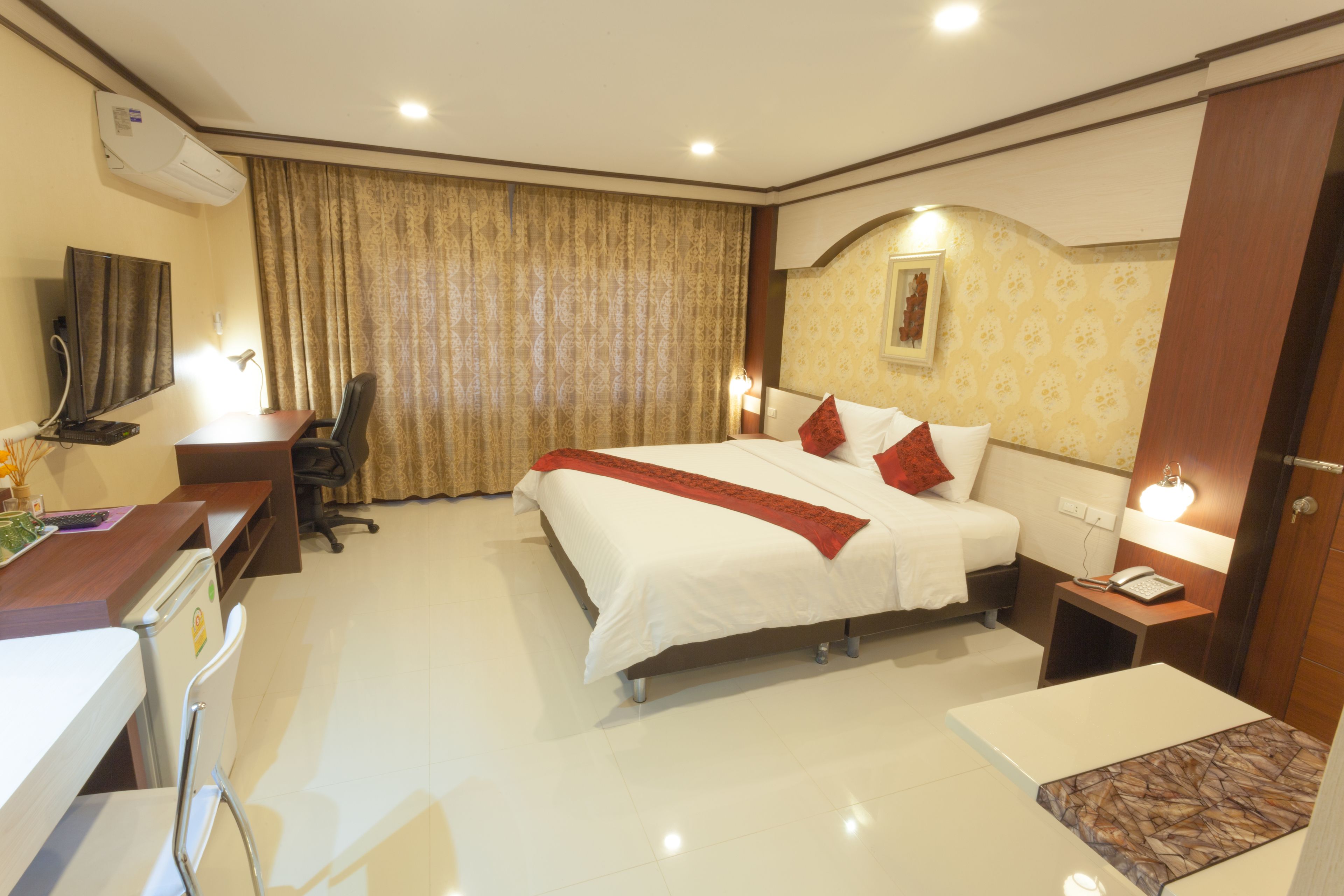 Una habitación de hotel con cama, escritorio, silla y una mesita.