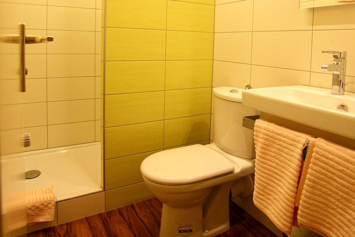 A bathroom with a toilet, sink, and shower.