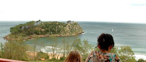 Un balcón con vistas al mar y una pequeña isla.