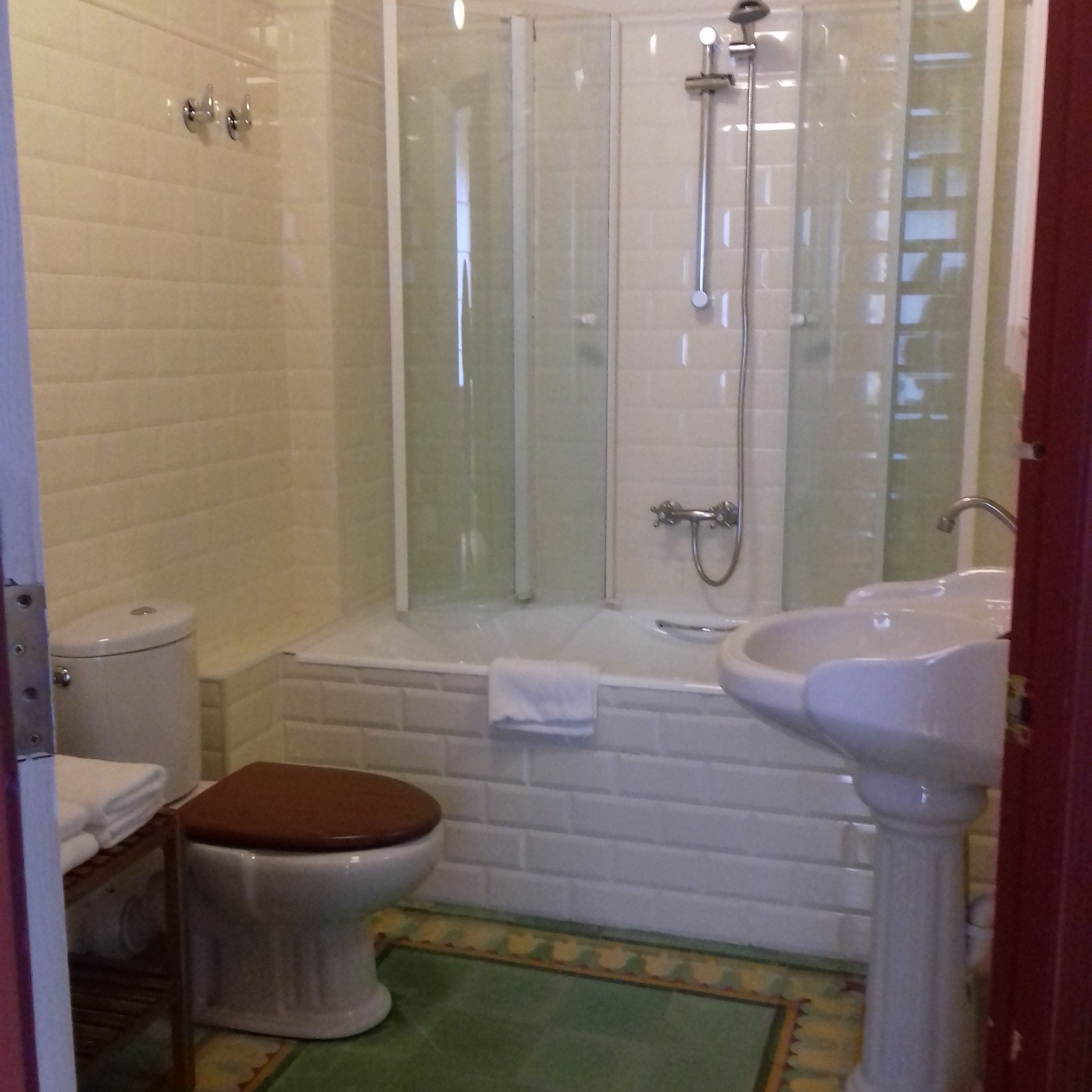 Un baño con inodoro, cabina de ducha y lavamanos.