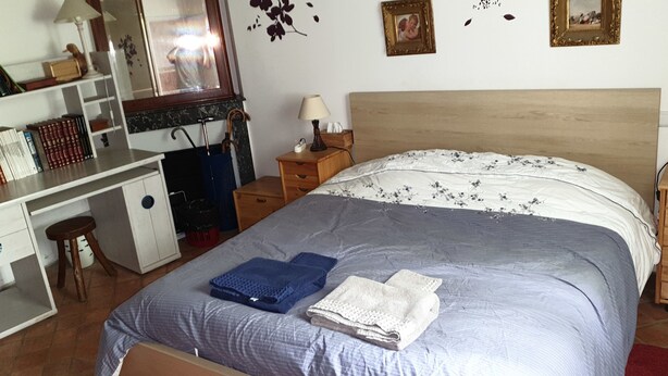 A bedroom with a bed, a desk, a chair, a dresser, and a small stool. - Coffret d'Avenir (Saint-Denis-en-Val)