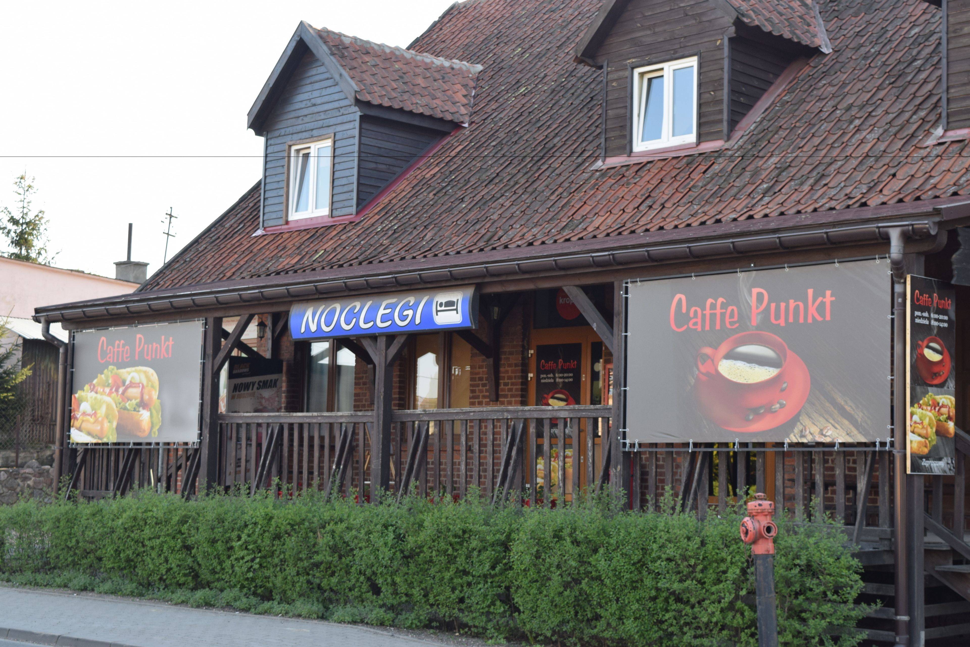A building with a sign reading "Caffe Punkt" and another sign "Noclegi".