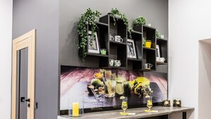 A modern kitchen with a dark grey wall, wooden floor, and bar stools. - ApartMood (Katowice)