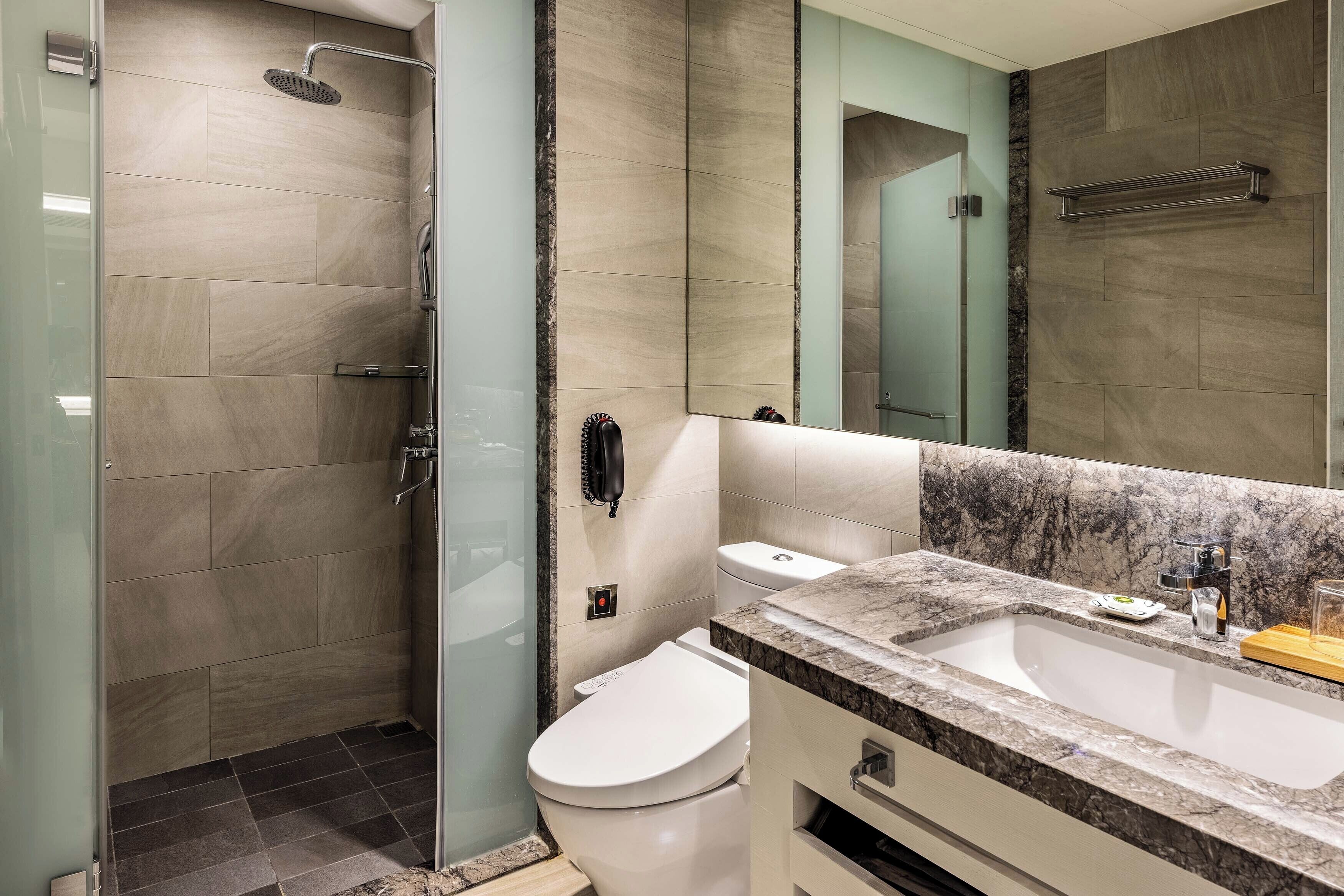 Ein modernes Badezimmer mit Dusche, Toilette und Waschbecken.