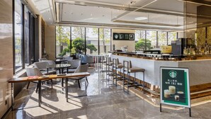 A modern coffee shop with a bar area, seating, and large windows. - Hsin Hotel (Chiayi City)
