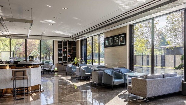 A modern interior with a bar area, seating, and large windows offering a view of the outdoors. - Hsin Hotel (Chiayi City)