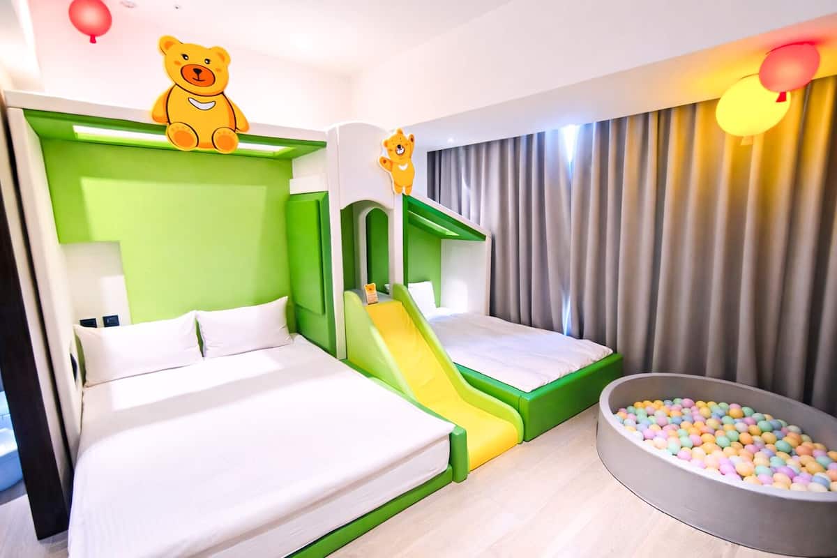 A children's room with a bed, a slide, and a ball pit.