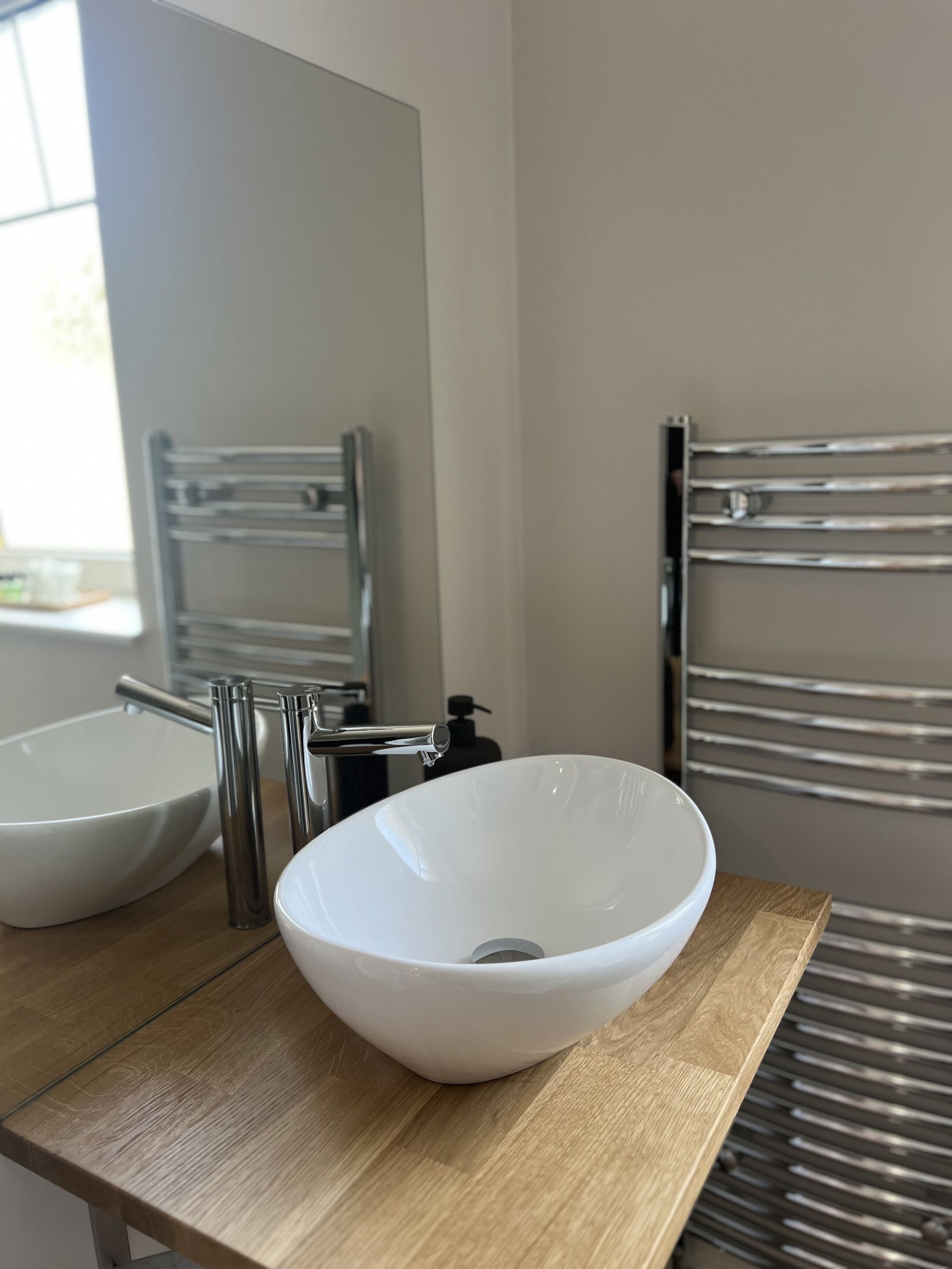 Une salle de bain avec un lavabo blanc, un miroir et un porte-serviettes.