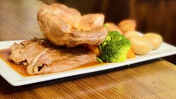 A plate of food with meat, broccoli, and potatoes on a wooden table.