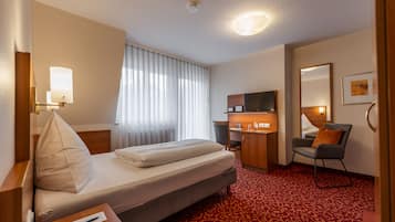 Ropa de cama hipoalergénica y caja de seguridad en la habitación