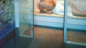 A glass-enclosed room with a bathtub, a shower, and a glass door. - Hotel Alexa (Bad Mergentheim)