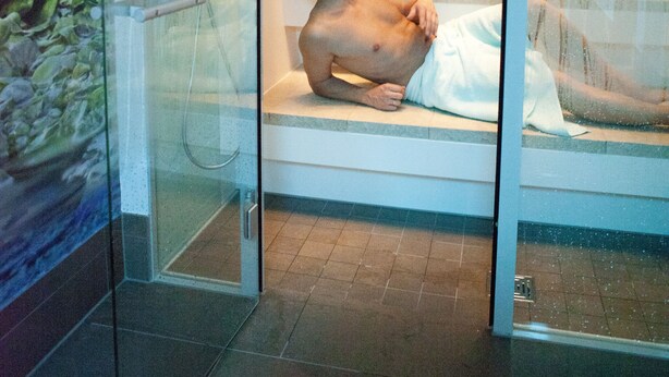 A glass-enclosed room with a bathtub, a shower, and a glass door. - Hotel Alexa (Bad Mergentheim)