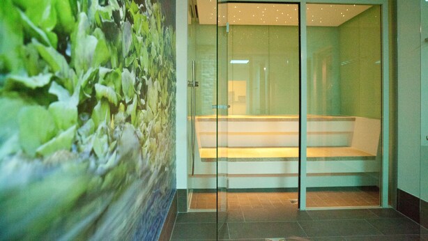 A modern interior with a glass door leading to a seating area. - Hotel Alexa (Bad Mergentheim)
