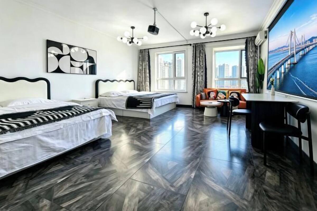 Une chambre d’hôtel moderne avec un grand lit, un bureau et une vue sur un pont.