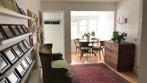 A living room with a green armchair, a wooden coffee table, and a red patterned rug. - Ølsted Kro (Olsted)